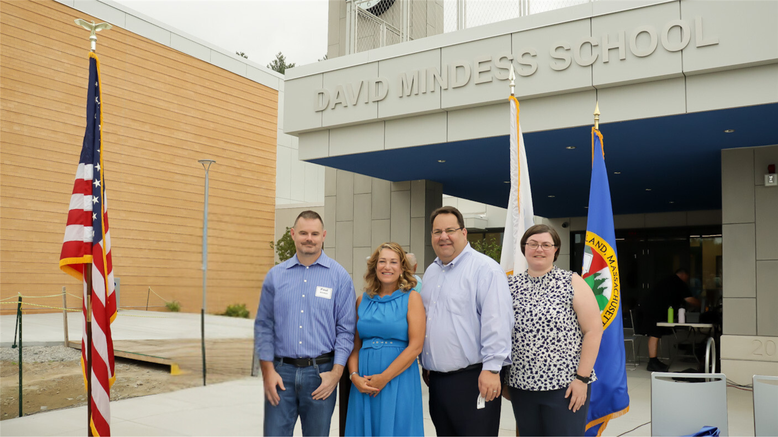  Four Ashland School Committee members pose for a group photo in front of the new Mindess School.